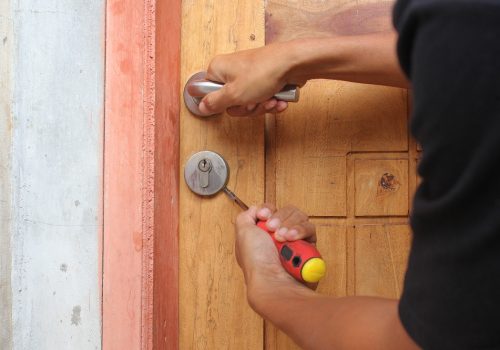 A,Person's,Hands,Using,A,Screwdriver,To,Pick,The,Lock